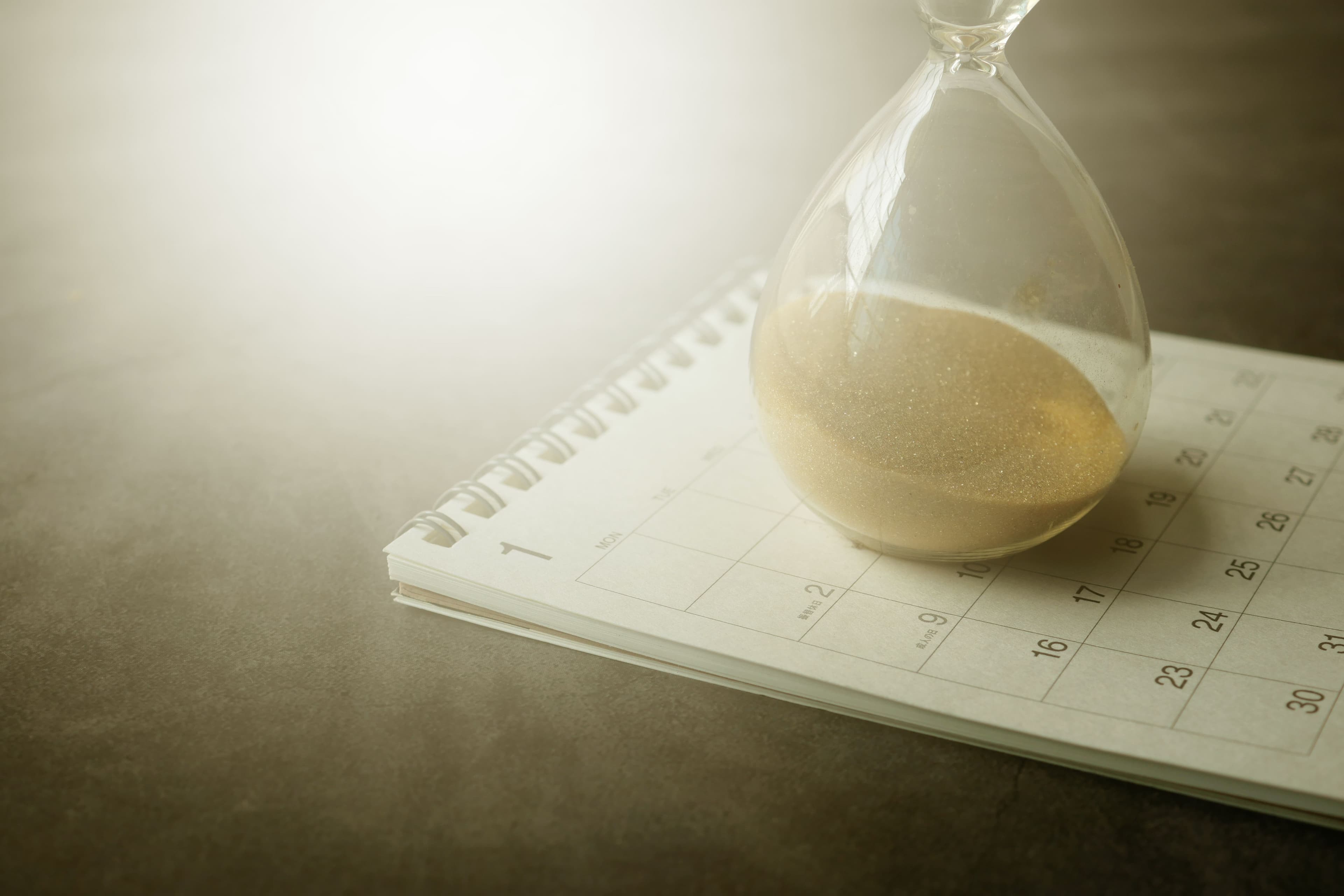 An hourglass resting on a calendar, symbolizing the passage of time and how quickly life can feel.